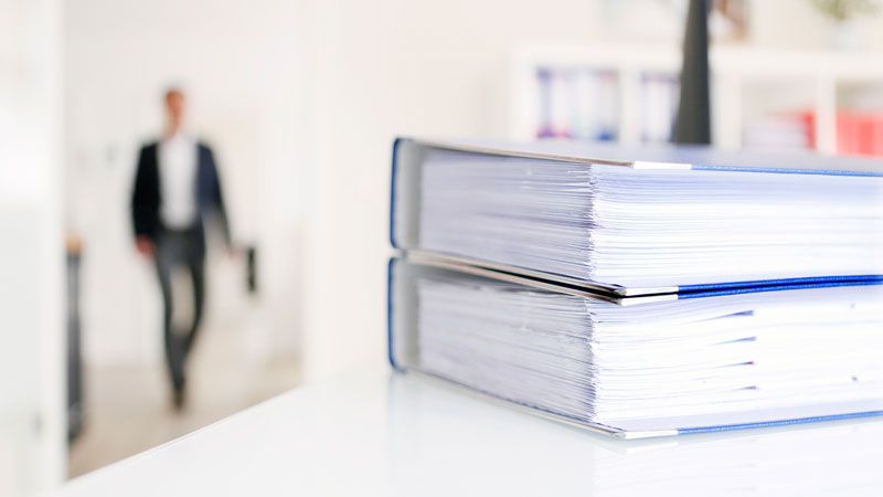 Motiv Lohnbuchhaltung, Bücher im Vordergrund, unscharfer Hintergrund